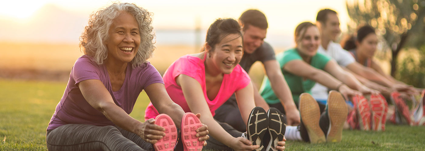 Adults stretching in park